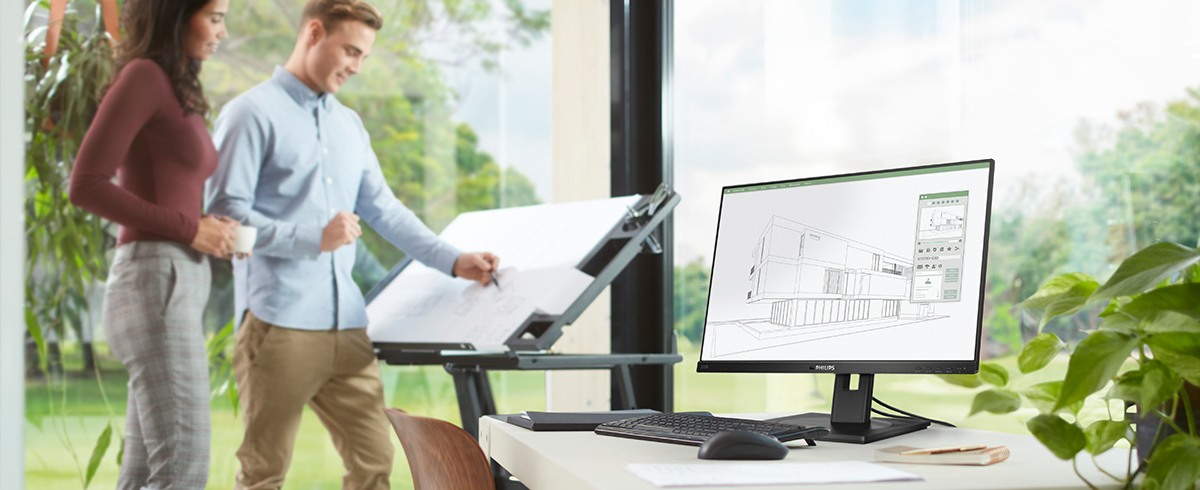 Ludzie cieszą się z miejsca pracy dzięki zielonym, ekologicznym monitorom Philips.