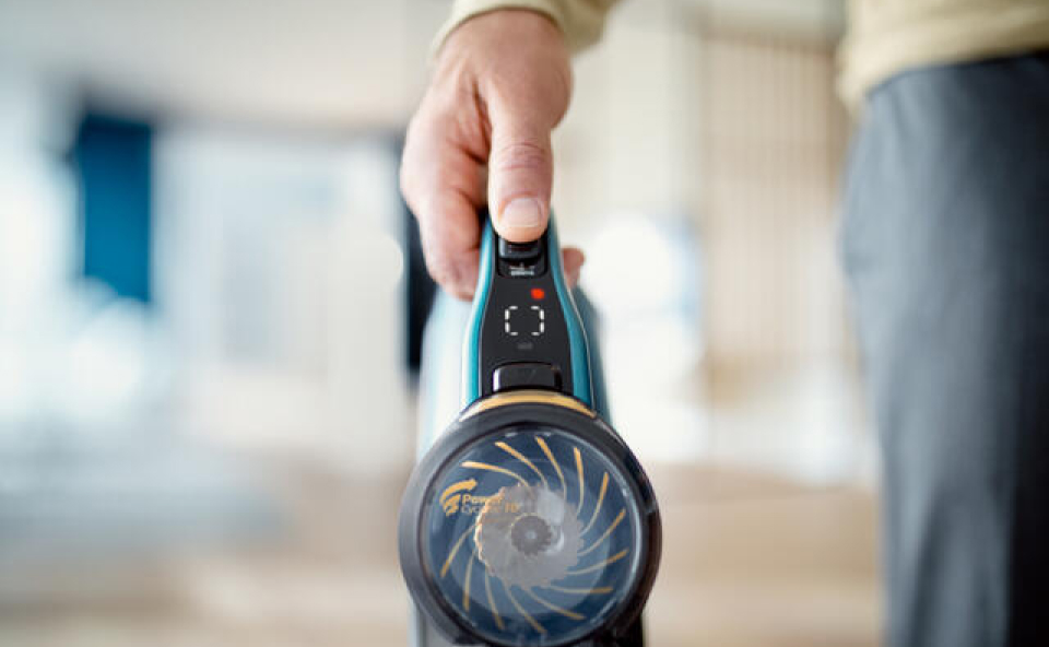 Mężczyzna używa odkurzacza bezprzewodowego