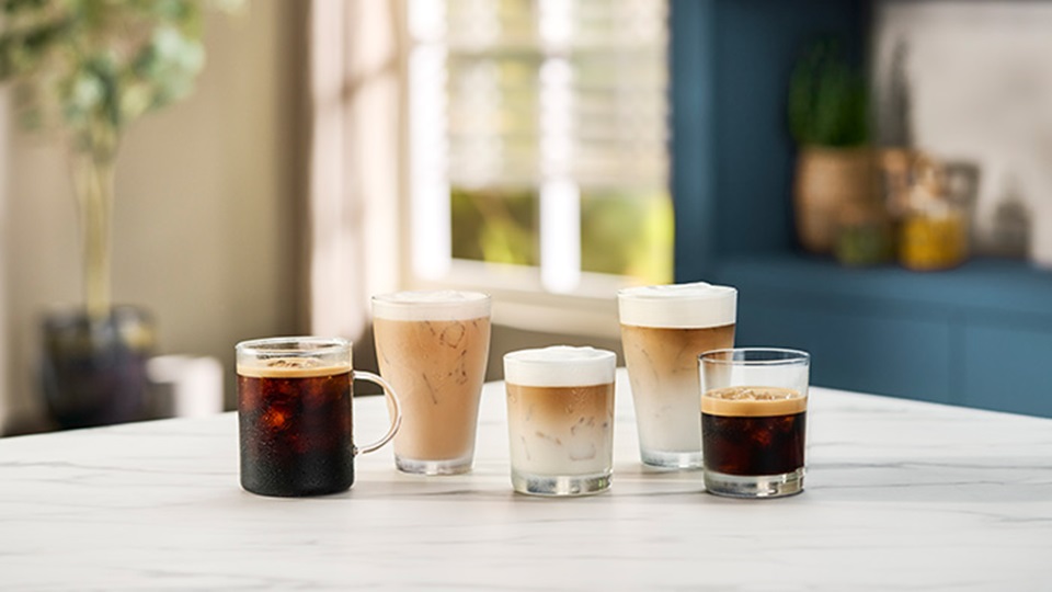 Kobieta chłodzi się w gorący dzień, popijając kawę cold brew z kostkami lodu.