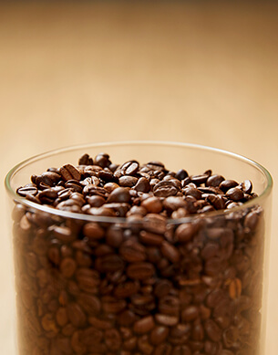 Szklanka pełna ziaren kawy