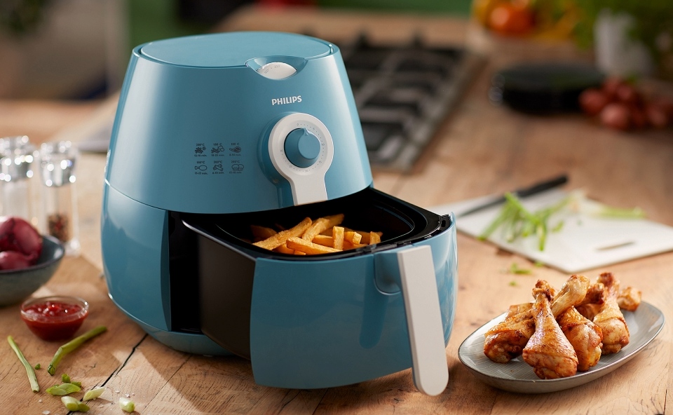 Frytki i kurczak przygotowany w niebieskim airfryerze.