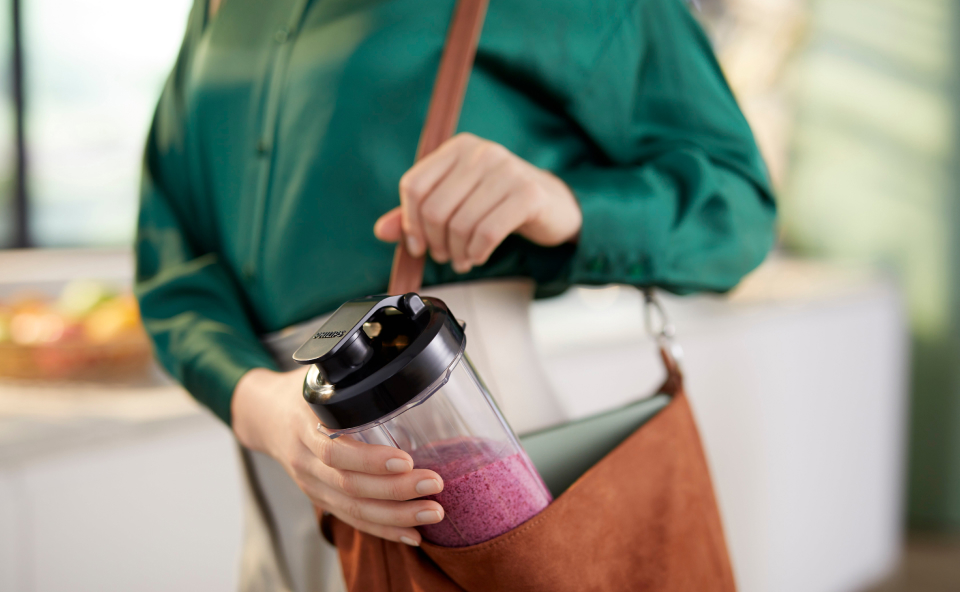 Kobieta wkłada gotowe smoothie do torby