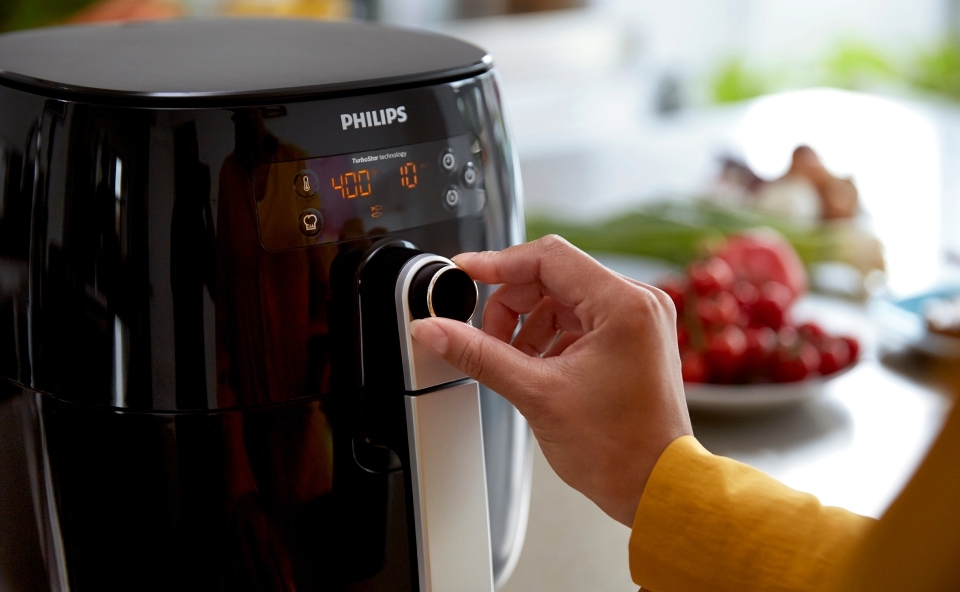 Kobieta ustawia temperaturę i czas pieczenia kalafiora w airfryerze.