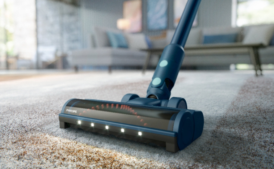 Czyszcenie dywanu z sierści psa odkurzaczem bezprzewodowym z elektroszczotką.