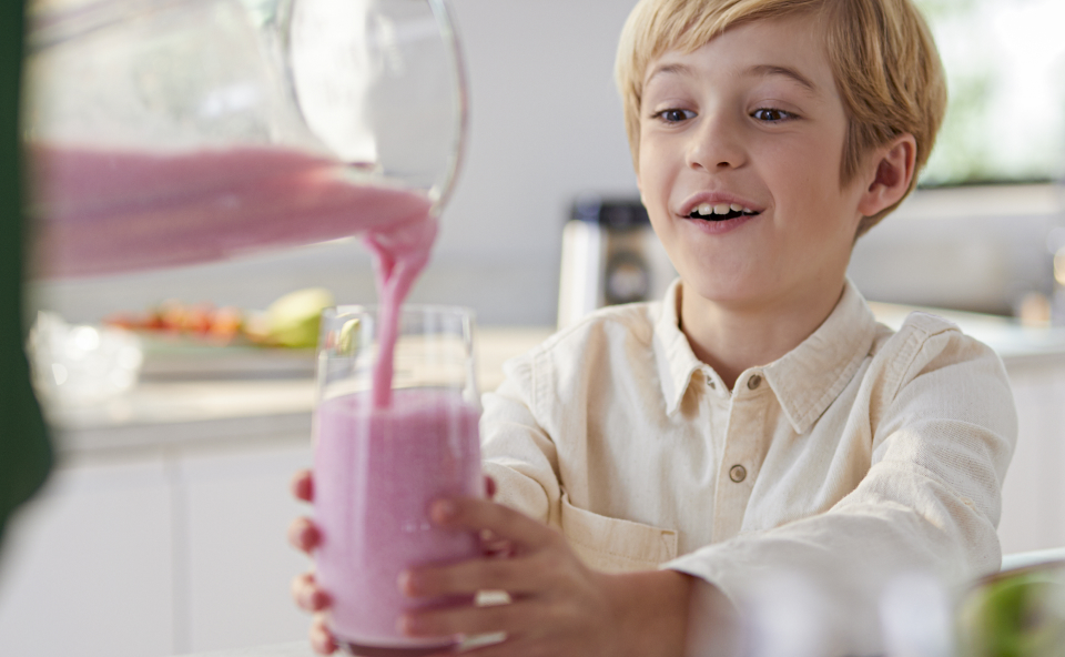 Mama nalewa dziecku koktajl truskawkowy