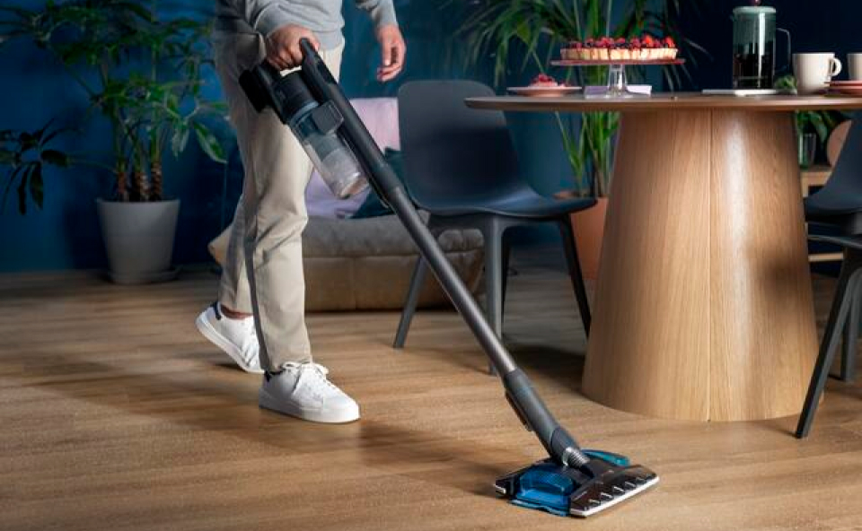 Osoba sprząta podłogę odkurzaczem do dużego domu