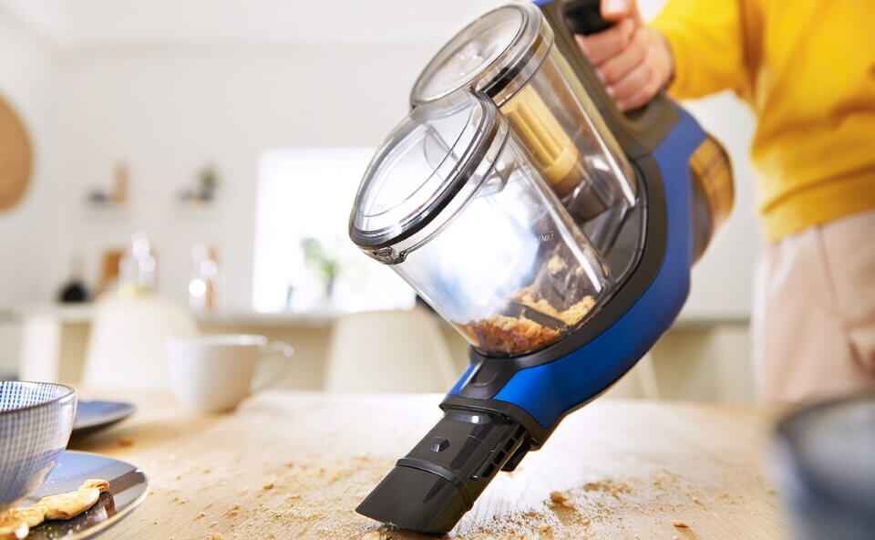 Odkurzanie okruszk&oacute;w na stole odkurzaczem pionowym bez rury