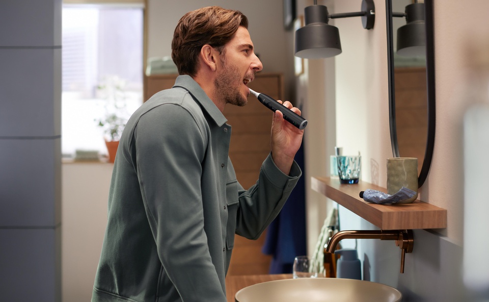 Mężczyzna myjący zęby szczoteczką soniczną Philips