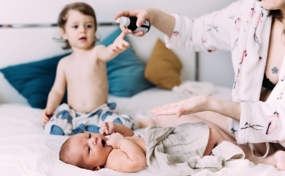  Kobieta pielęgnuje sk&oacute;rę dziecka po kąpieli.