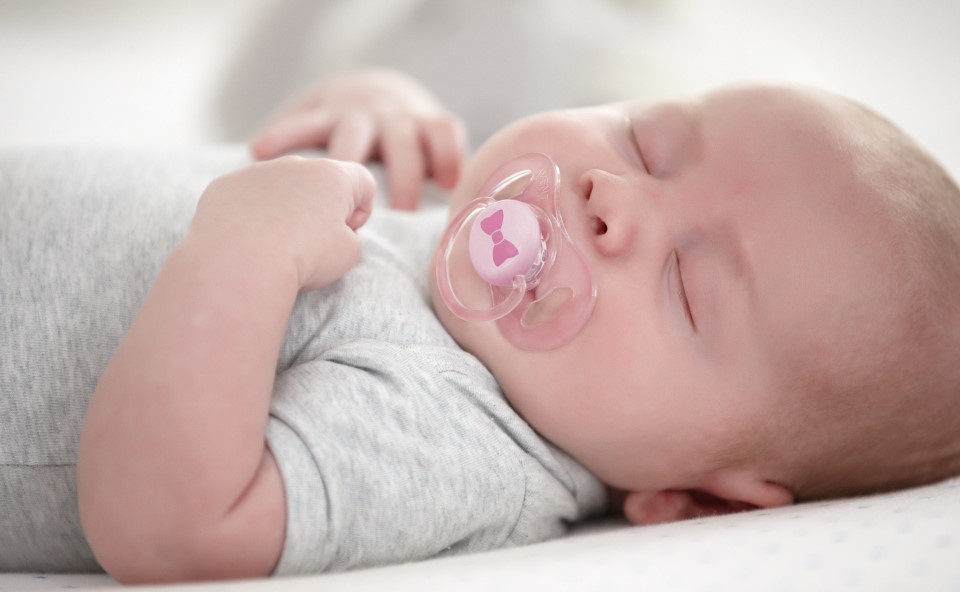 Śpiące dziecko ze smoczkiem.