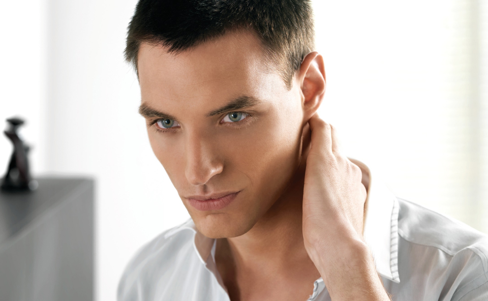 Mężczyzna trzymający się za tył szyji