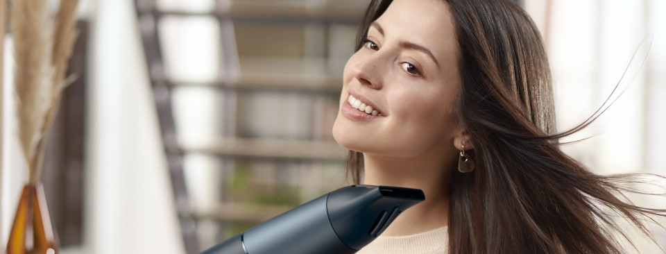 Kobieta suszaca wlosy suszarka