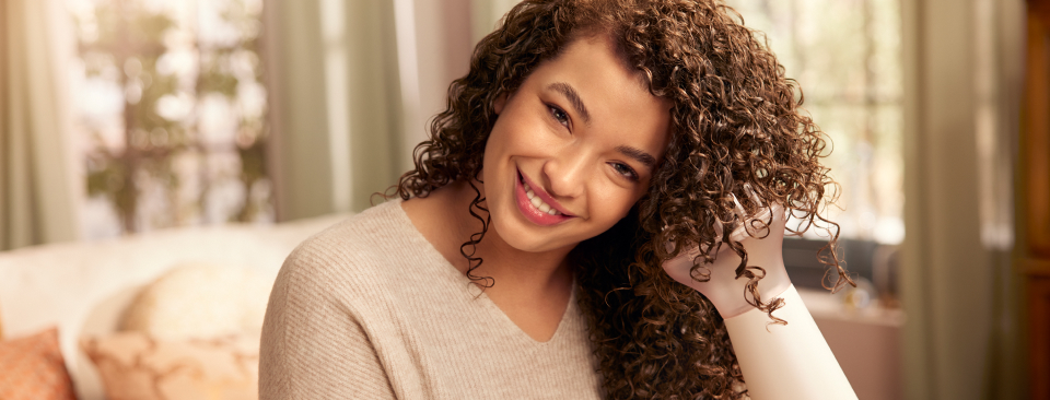 Kobieta susząca kręcone włosy suszarką