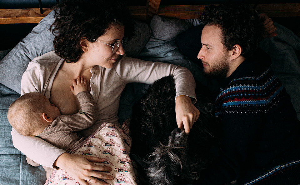 Mama karmiąca dziecko piersią w ł&oacute;żku