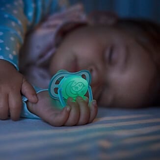 Dziecko trzymające smoczek w dłoni