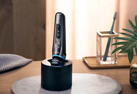 Golarka S9000 w trakcie czyszczenia w bezprzewodowej stacji Quick&nbsp;Clean&nbsp;Pod.